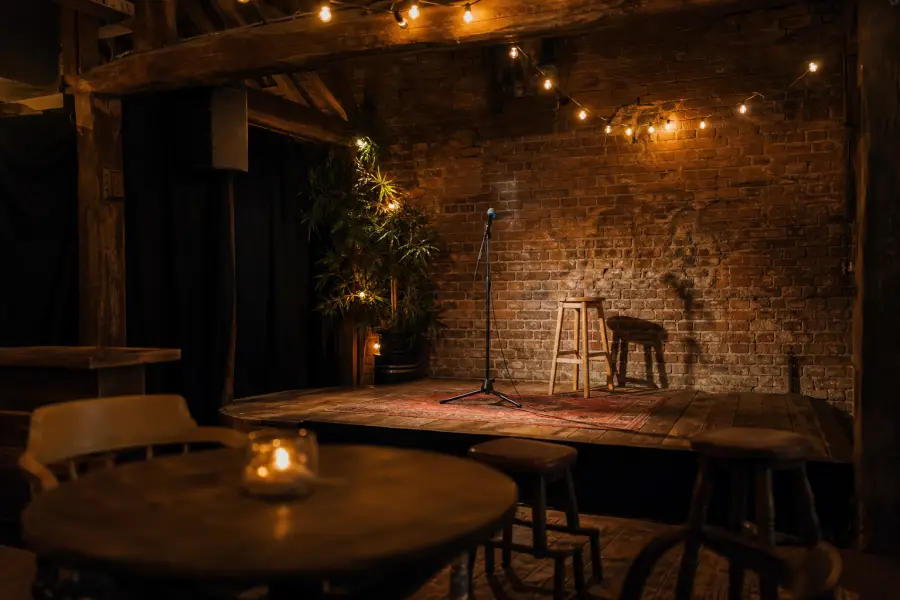 A microphone on a small stage in a brick-walled venue